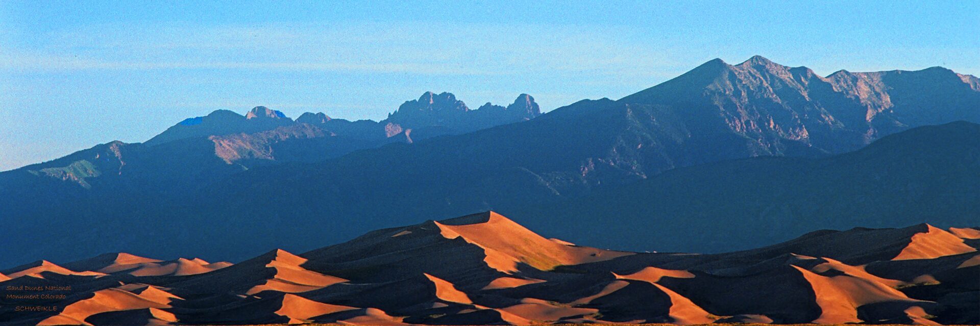 A desert landscape with mountains in the background.